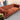 Rust-colored Chesterfield 3-seater fabric sofa with deep tufting and rolled arms in a showroom display setting
