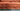 Close-up of rust-colored fabric sofa cushions with deep button tufting on a Chesterfield 3-seater sofa
