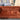 Rust velvet Chesterfield 3 seater sofa with deep button tufting and rolled arms in showroom environment