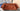 Rust velvet Chesterfield 3 seater sofa with deep button tufting and rolled arms in showroom environment