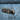 Close-up of USB charging port and control buttons on blue fabric armchair side panel with brass finish trim