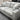 Gray sectional sofa with cushions in a showroom setting