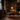 Club leather effect black vintage armchair beside a fireplace in a book-lined study