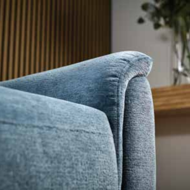 Close-up of soft blue fabric upholstery on armrest of Gemina dual power recliner armchair in modern living room setting