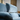 Close-up of blue fabric Gemina armchair showcasing adjustable headrest and plush cushioning in modern interior setting