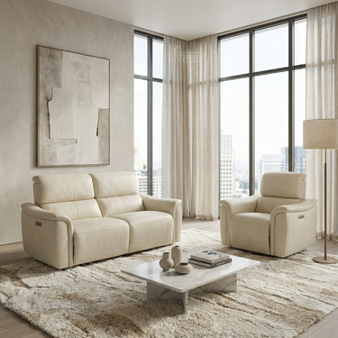 Cream leather dual power recliner armchair with adjustable headrest alongside matching two-seater sofa in sunlit modern living room