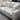 Gray sectional sofa with cushions in a showroom setting