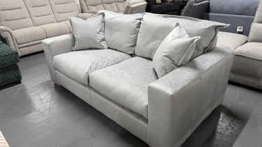 Gray sectional sofa with cushions in a showroom setting