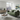 Modern green Penny 3 seater fabric sofa with cushions in a bright living room with city view window and artwork on wall.
