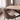 Sadina dining set close-up of a quilted biscuit chair beside the curved oak-effect table edge by a window